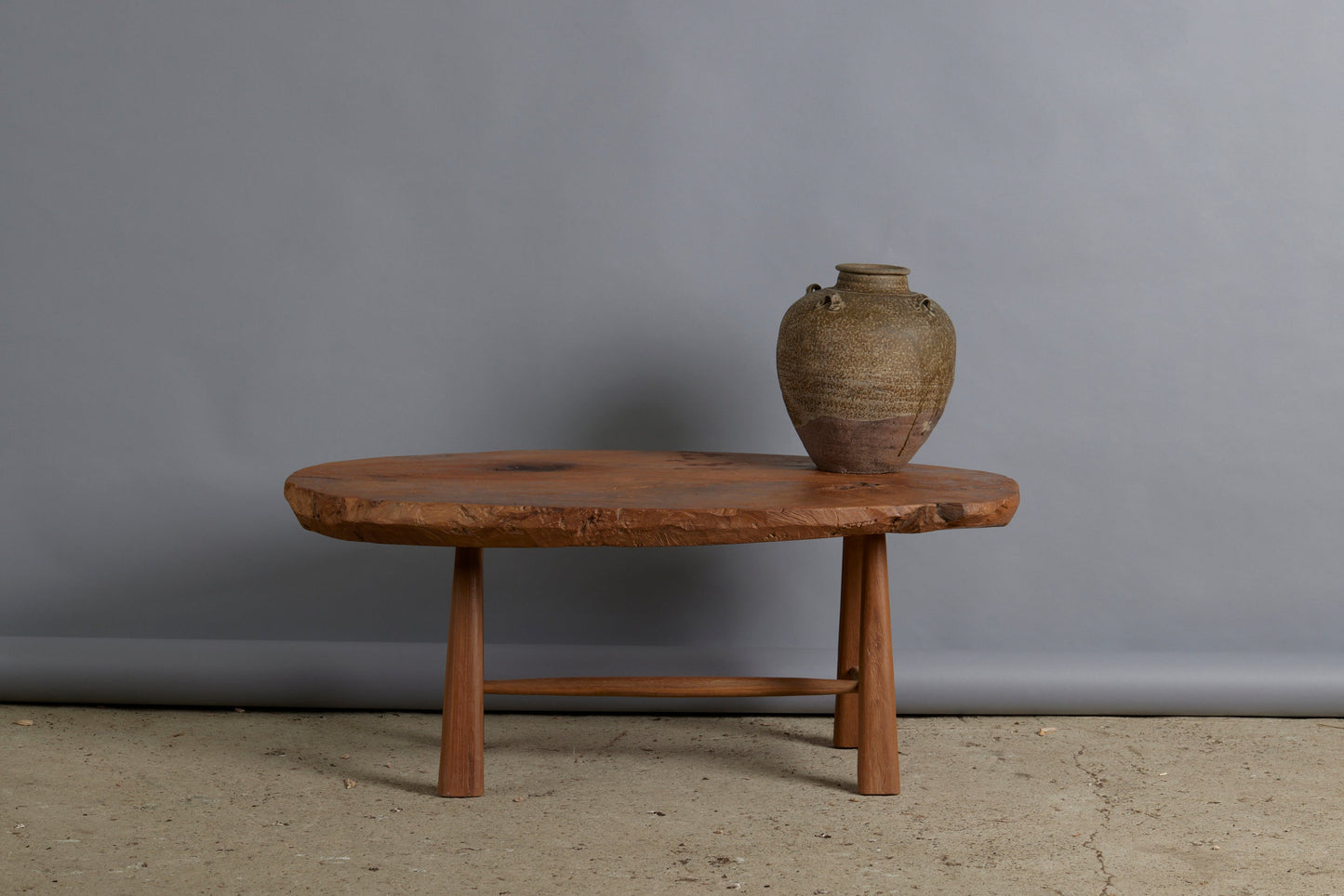 Primitive Oval Top Burled Teak Coffee Table with a Turned Stretcher Base