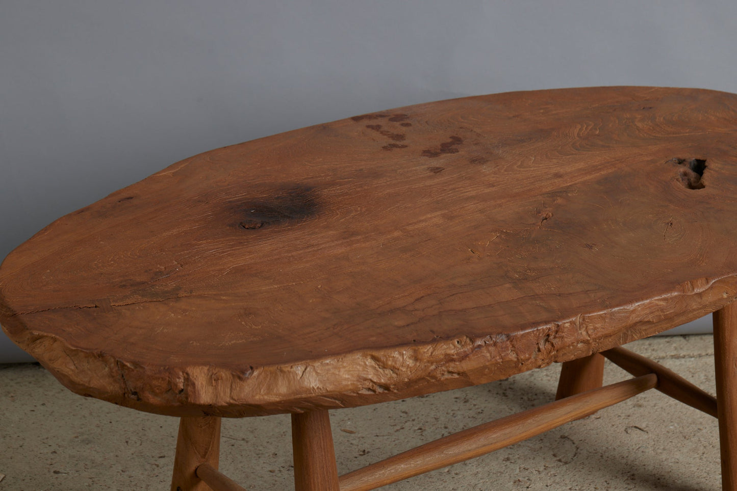 Primitive Oval Top Burled Teak Coffee Table with a Turned Stretcher Base