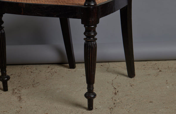 Pair of Ebonized Raffles Chairs with Greeted Arms Gadrooned Legs and Tanned Seats