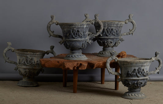 Set of Four English Late 19th Century Cast Lead Urns with Griffin Handles and Cast Applied Puttis in a Challased Form