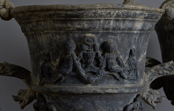 Set of Four English Late 19th Century Cast Lead Urns with Griffin Handles and Cast Applied Puttis in a Challased Form